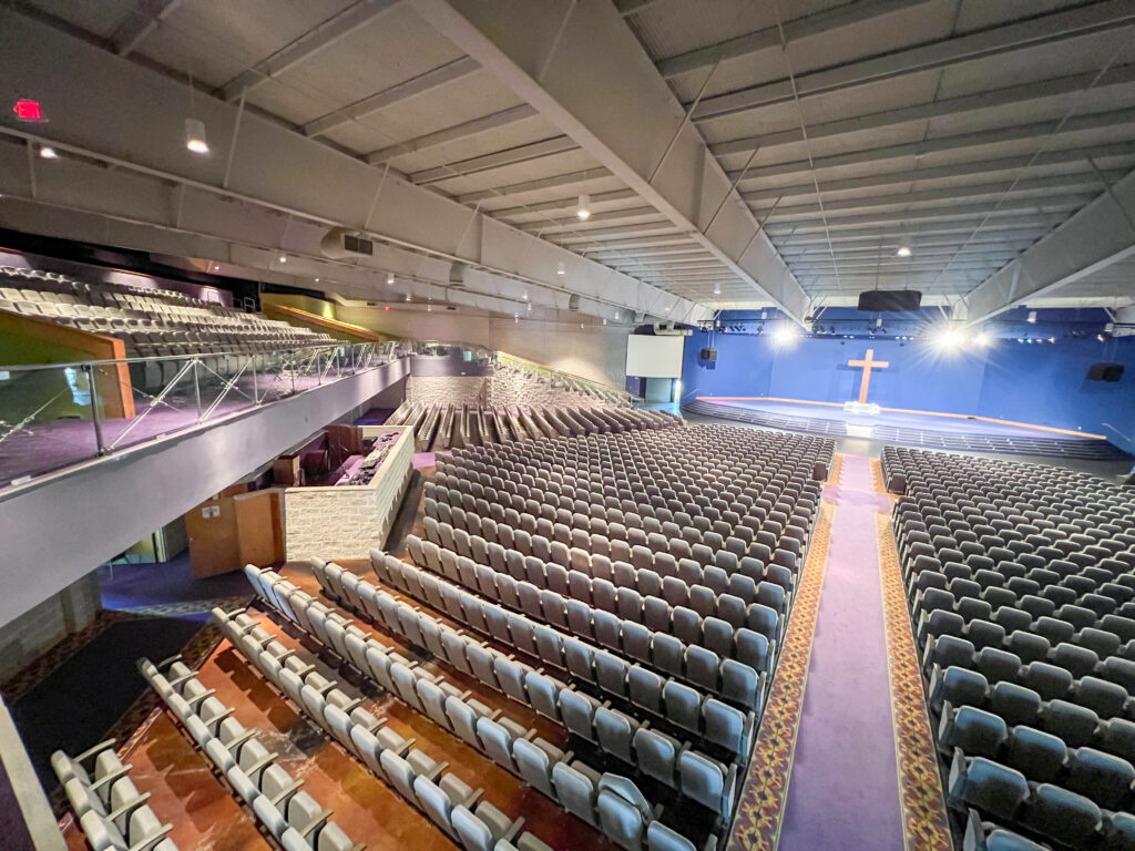 Spacious interior of the main sanctuary at the I-12 Regional Church & Event Campus in Hammond, LA, featuring fixed seating for 3,000, elevated stage with AV setup, and architectural lighting designed for worship services, conferences, and large-scale events.